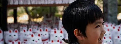 Voyage au Japon en famille : enfant découvrant le temple des maneki-neko à Tokyo