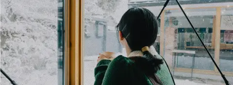 Moment de pause lors d’un voyage au Japon en hiver, observation des paysages enneigés depuis l’intérieur