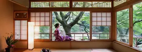 Femme en kimono dans une demeure japonaise traditionnelle ouverte sur un jardin à Kyoto